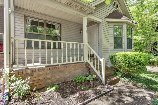 a view of a house with a small yard and wooden floor and fence