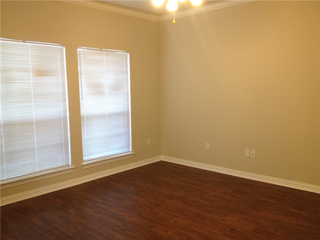 1001 Krenek Tap Road, Unit 1504 College Station, TX 77840 - Photo 3 of 8 an empty room with wooden floor and windows