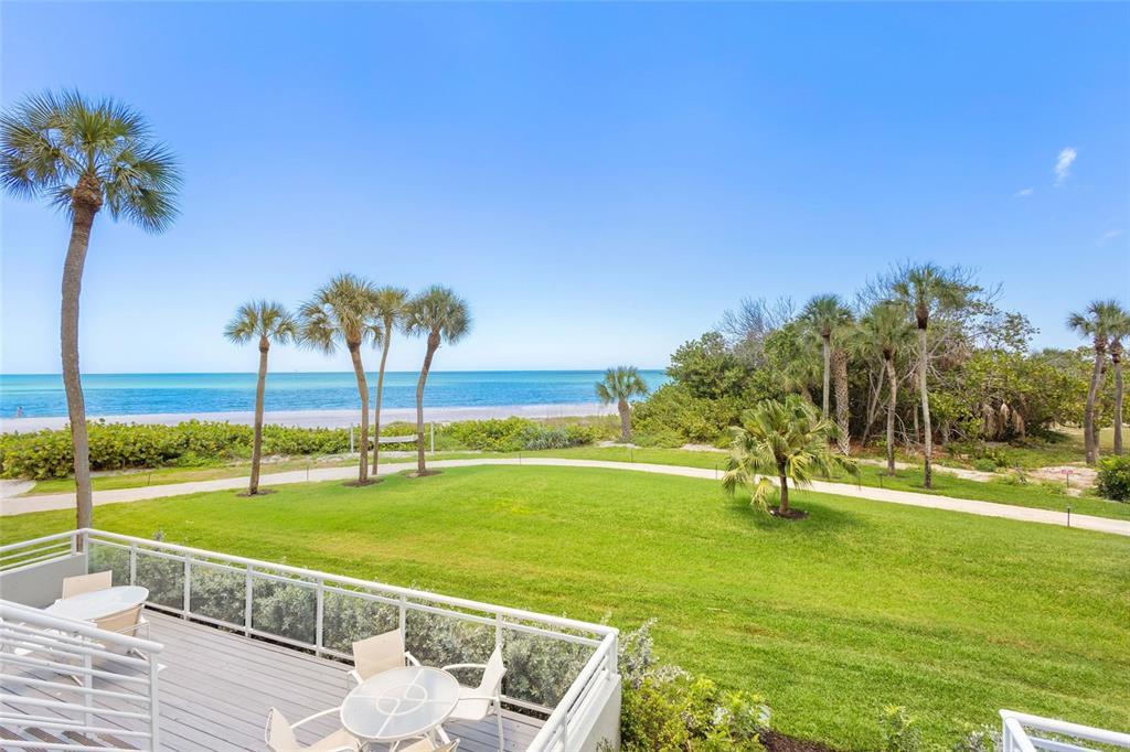 240 Sands Point Road, Unit 4104 Longboat Key, FL 34228 - Photo 25 of 47 a view of a swimming pool with a yard and palm trees