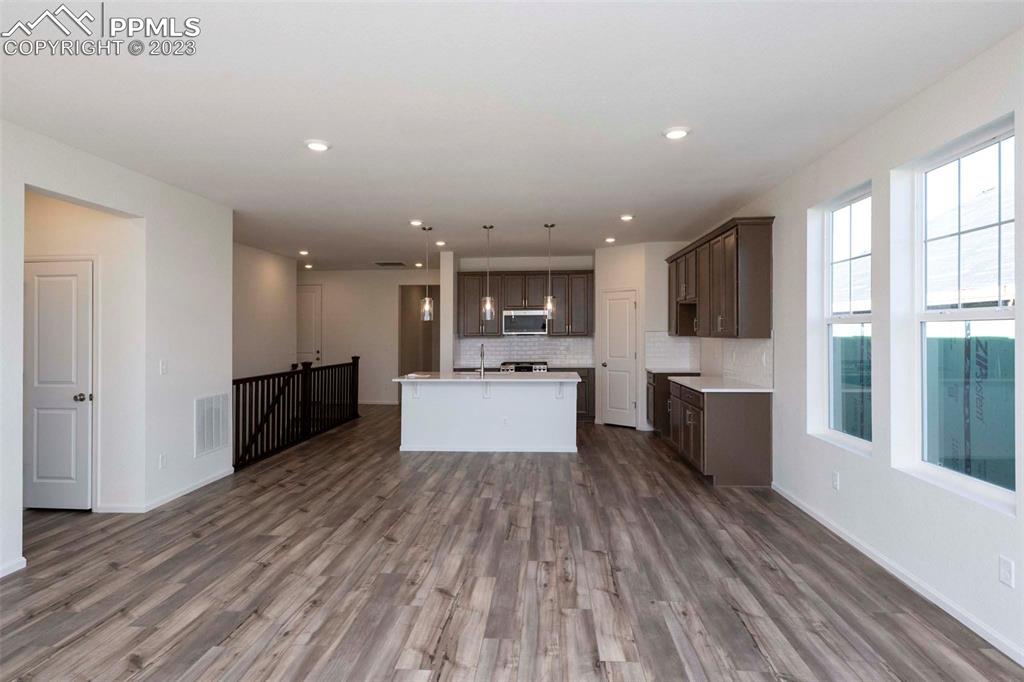 2057 Peachleaf Loop Castle Rock, CO 80108 - Photo 7 of 23 a large kitchen with stainless steel appliances kitchen island a large counter top and a wooden floors