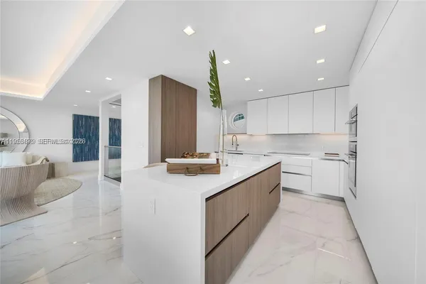 a large kitchen with stainless steel appliances kitchen island granite countertop a sink and cabinets