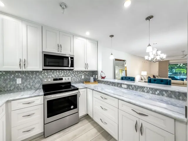 a kitchen with white cabinets stainless steel appliances and white cabinets