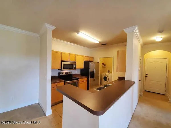 a room with stainless steel appliances kitchen island granite countertop a sink and cabinets