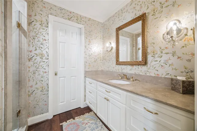 a bathroom with a granite countertop sink a mirror and a shower