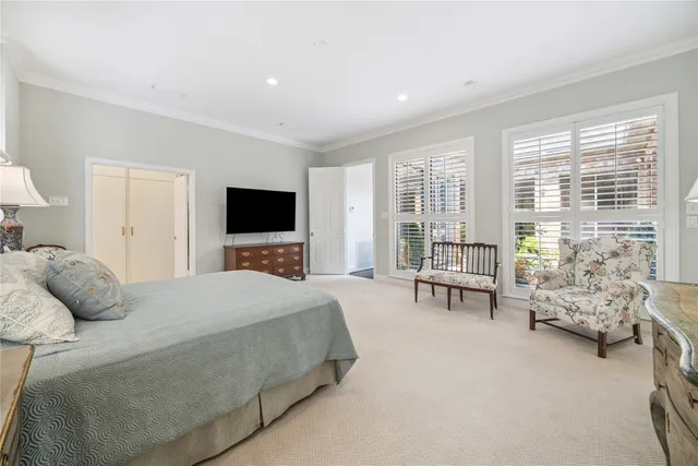 a bedroom with a bed and large windows