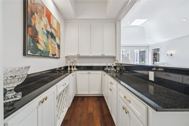 a kitchen with granite countertop a sink stove and cabinets