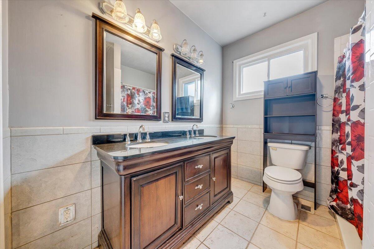 3116 Spring Road Southwest Roanoke, VA 24015 - Photo 11 of 22 a bathroom with a toilet a sink and mirror