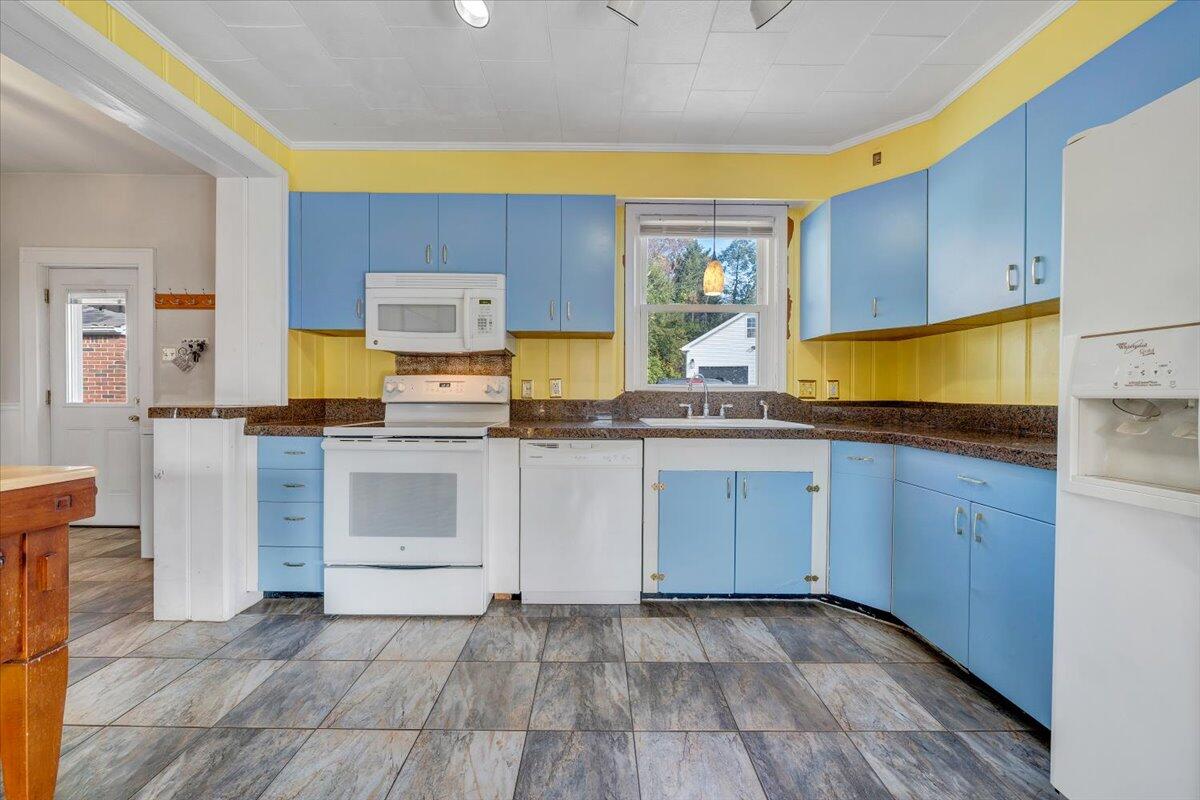 3116 Spring Road Southwest Roanoke, VA 24015 - Photo 6 of 22 a kitchen with granite countertop a stove a sink and a refrigerator