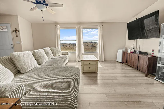 a living room with a bed furniture and next to a window
