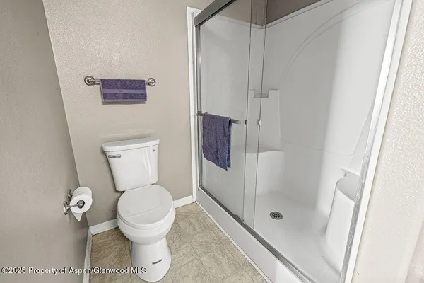 a bedroom with a bed and a flat tv screen on the dresser