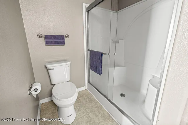 a bedroom with a bed and a flat tv screen on the dresser