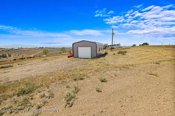 a view of a blue house with a yard