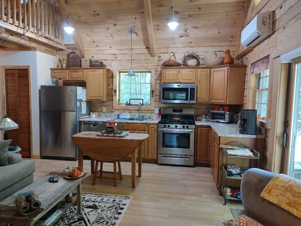 a kitchen with stainless steel appliances kitchen island granite countertop a refrigerator and a stove top oven
