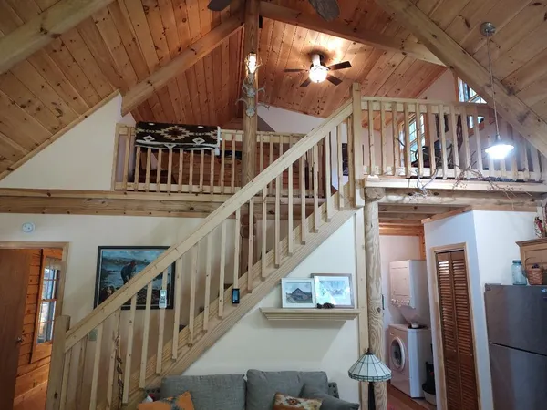 a view of staircase with lots of frames on wall and wooden floor