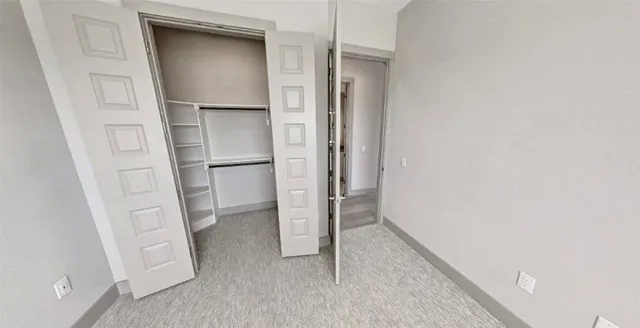 a view of walk in closet with empty racks