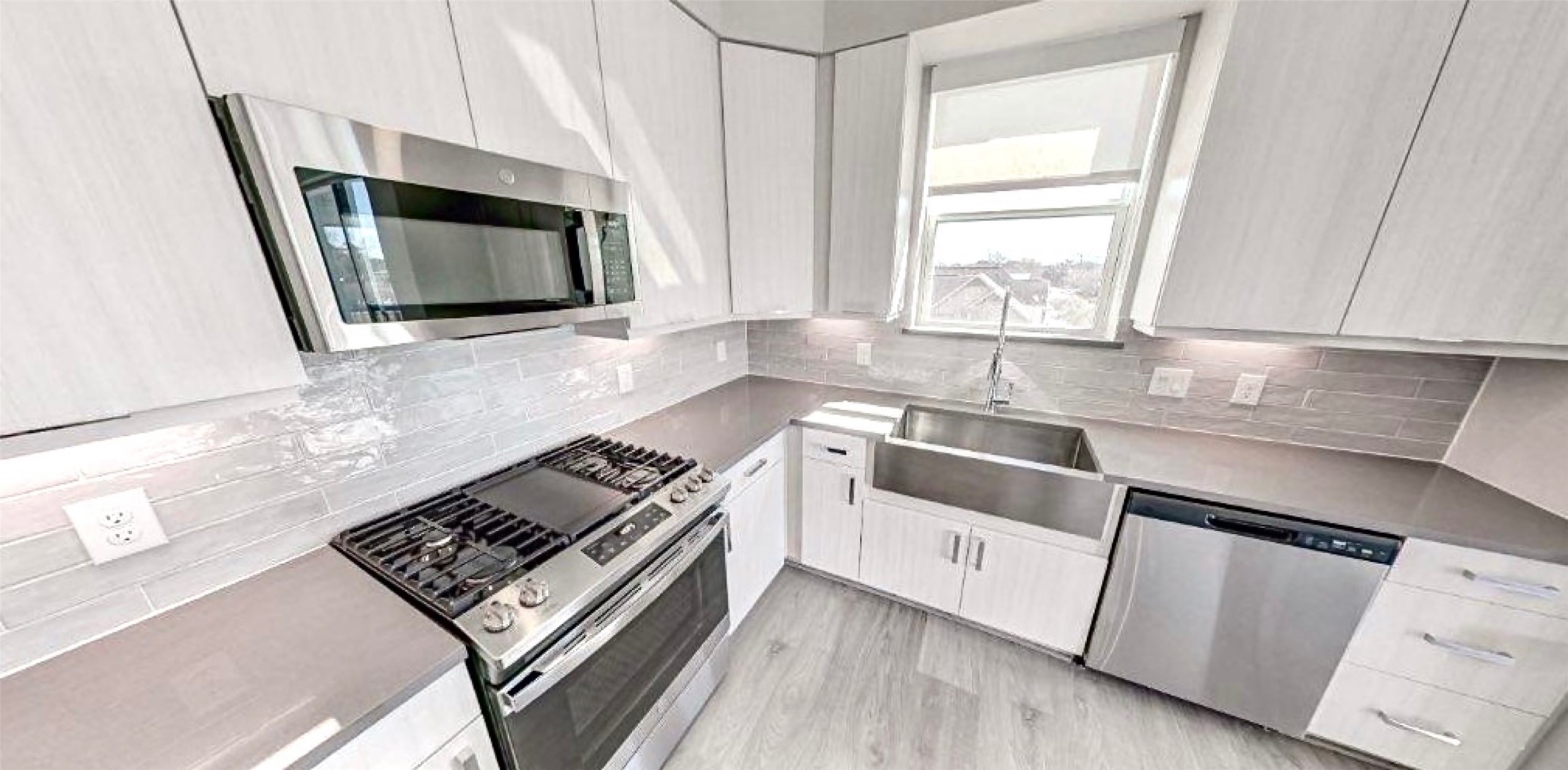401 West 25th Street, Unit 1144 Houston, TX 77008 - Photo 15 of 42 a kitchen with stainless steel appliances a stove a microwave a sink and white cabinets