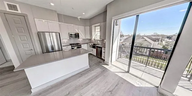 a view of a kitchen with fridge and wooden floor