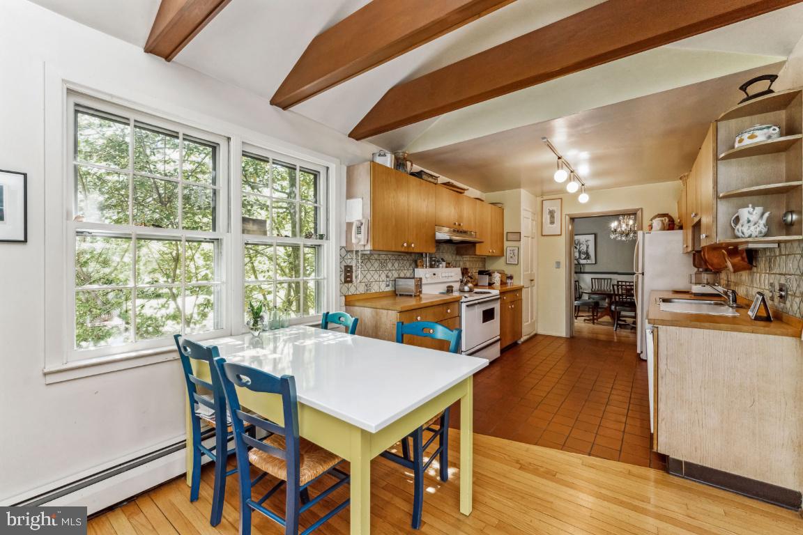 1807 Kenway Road Baltimore, MD 21209 - Photo 13 of 54 a kitchen with stainless steel appliances kitchen island granite countertop a table chairs and a wooden floor
