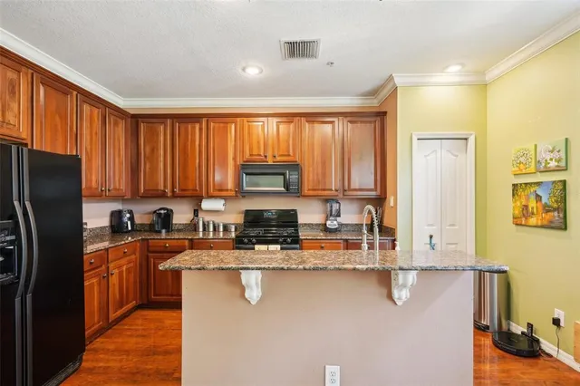 a large kitchen with stainless steel appliances granite countertop a stove a sink dishwasher a microwave oven with granite countertops and cabinets