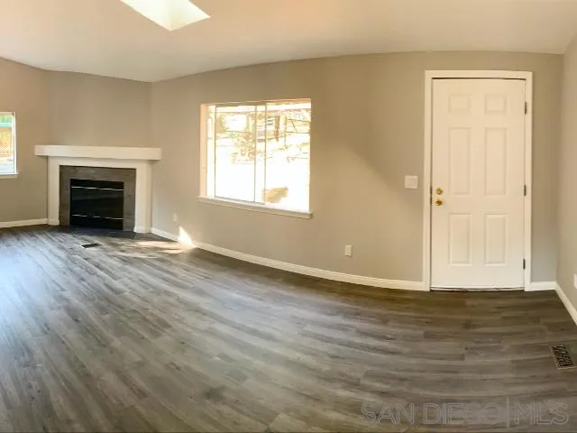 1618 Weekend Villa Road Ramona, CA 92065 - Photo 8 of 20 an empty room with wooden floor fireplace and windows
