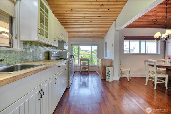 a kitchen with stainless steel appliances granite countertop wooden floors a stove and a sink