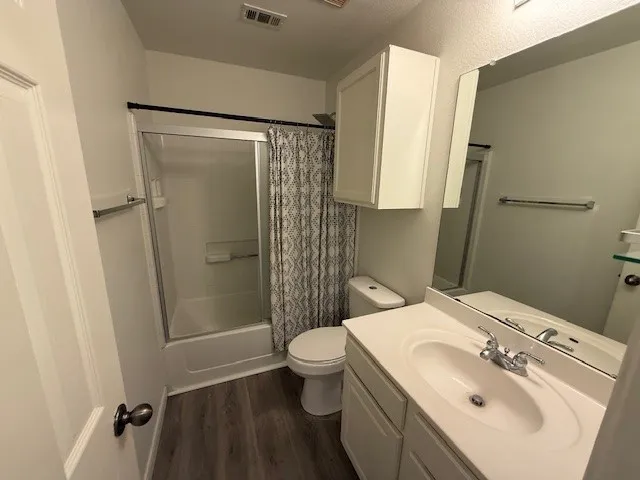 a bathroom with a tub shower and a sink