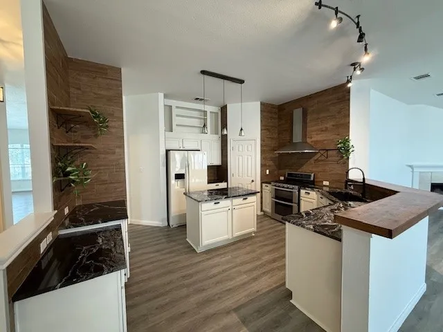 a kitchen with a refrigerator a sink and wooden floor