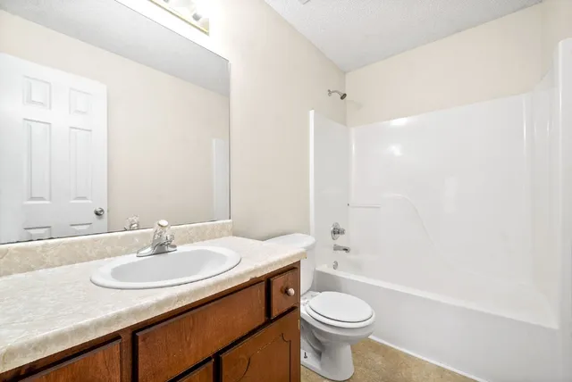 a bathroom with a sink a toilet a mirror and shower