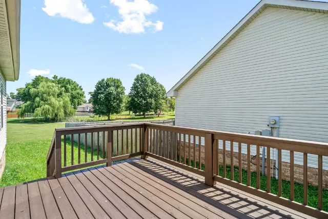 a view of deck with wooden floor and fence with a garden