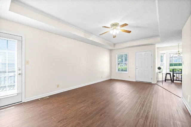 an empty room with wooden floor and windows