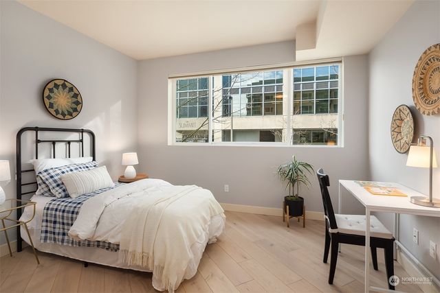 a bedroom with a bed two lamps and a large window
