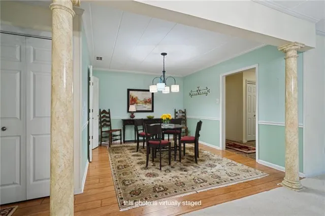 a view of a livingroom with wooden floor and a chandelier