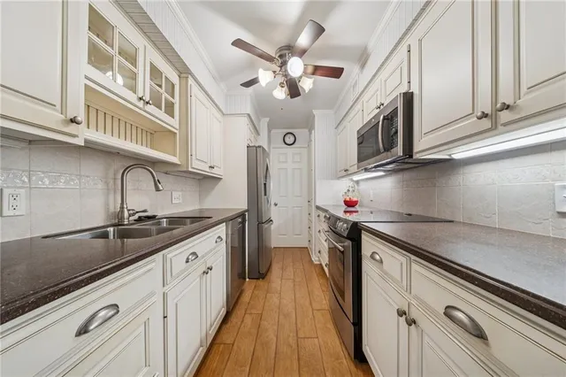 a kitchen with stainless steel appliances granite countertop a sink and a refrigerator