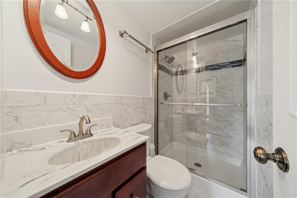 53 Highland Road, Unit 403404 Bethel Park, PA 15102 - Photo 21 of 33 a bathroom with a sink a mirror a toilet and a shower