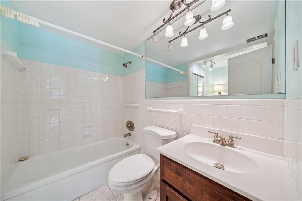 53 Highland Road, Unit 403404 Bethel Park, PA 15102 - Photo 24 of 33 a bathroom with a sink a toilet a mirror a bathtub and shower