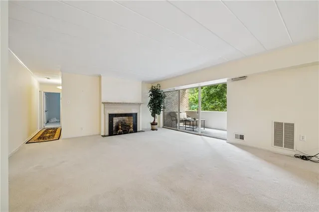 a view of a livingroom with an empty space and a fireplace