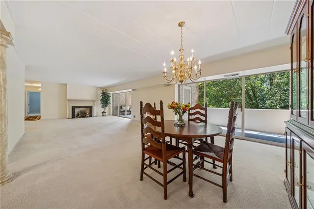 a dining room with furniture a chandelier and window