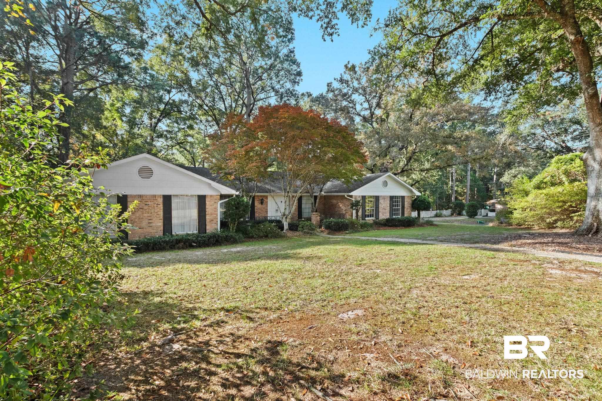752 Evergreen Street Fairhope, AL 36532 - Photo 95 of 100 View of front of home with a front lawn, brick siding, and view of wooded area