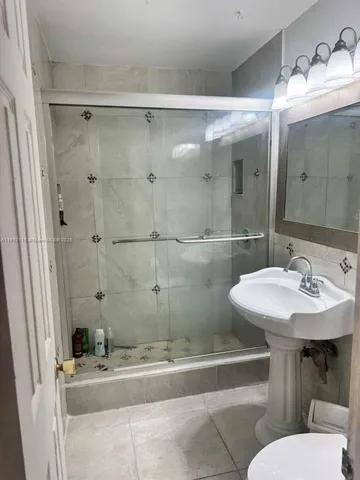 a bathroom with a sink mirror and a toilet