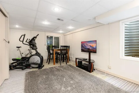 a backyard of a house with a large tree and wooden fence