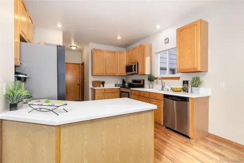 a kitchen with stainless steel appliances kitchen island granite countertop a refrigerator a stove and a sink