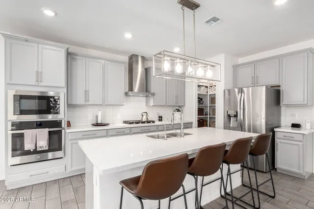 a kitchen with stainless steel appliances a stove a sink island and a refrigerator