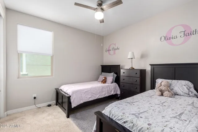 a bedroom with two beds and ceiling fan