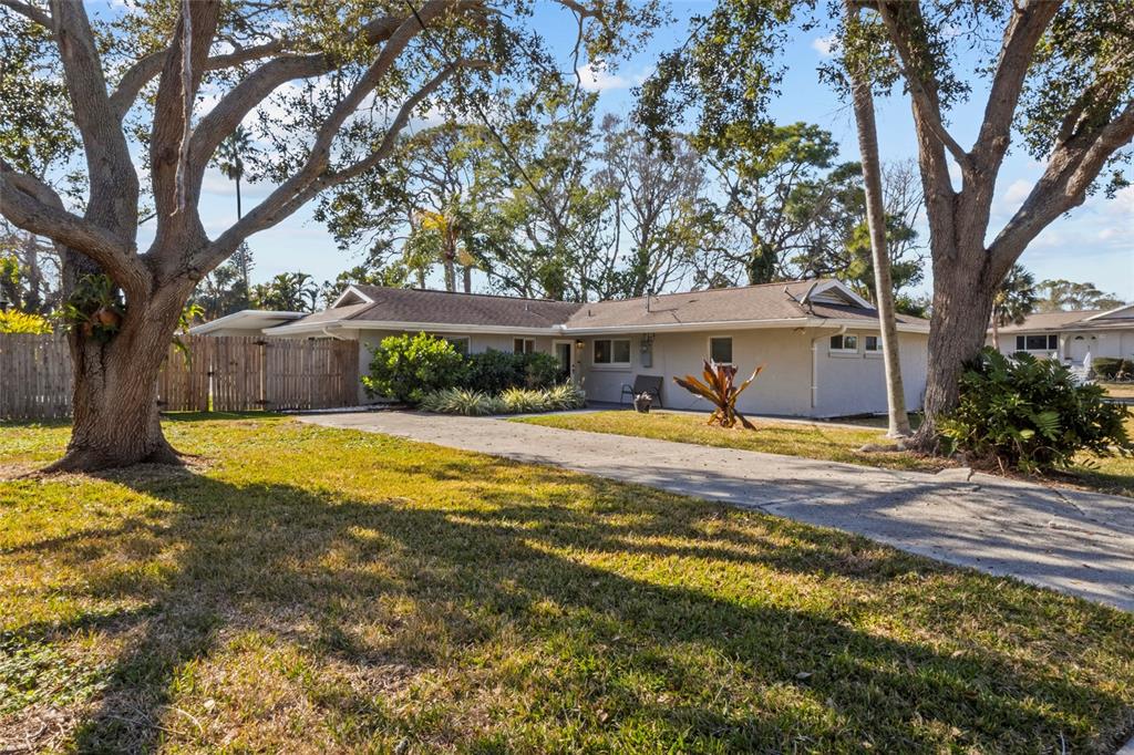 7230 Shepherd Street Sarasota, FL 34243 - Photo 1 of 30 a view of swimming pool with large trees and wooden fence