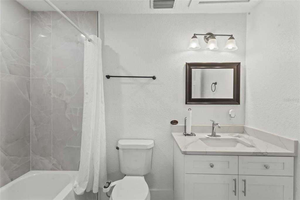 7230 Shepherd Street Sarasota, FL 34243 - Photo 16 of 30 a bathroom with a toilet a sink and mirror