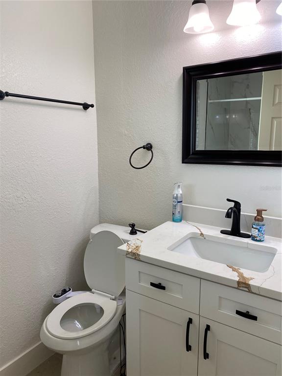 7230 Shepherd Street Sarasota, FL 34243 - Photo 23 of 38 a bathroom with a toilet sink and mirror