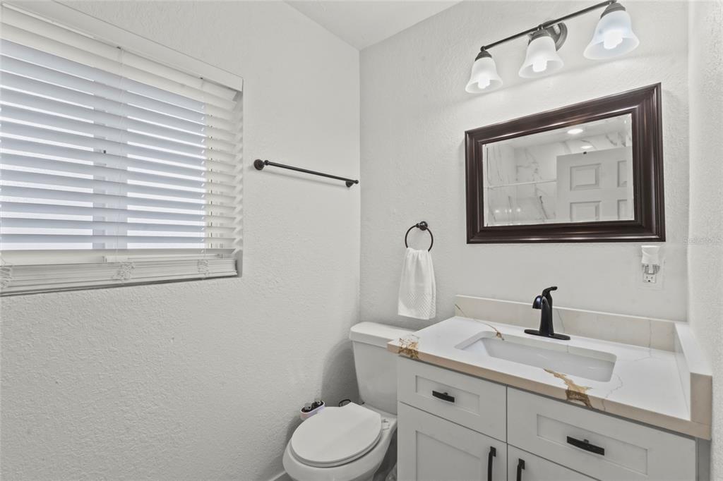 7230 Shepherd Street Sarasota, FL 34243 - Photo 8 of 30 a bathroom with a toilet sink and mirror