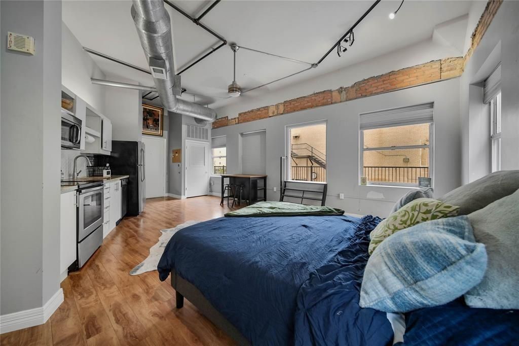 705 Main Street, Unit 610 Houston, TX 77002 - Photo 9 of 15 a spacious bedroom with a bed a window and dresser
