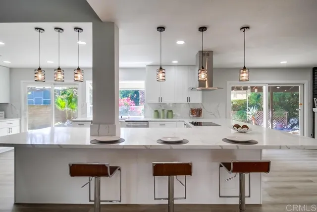 a large kitchen with stainless steel appliances kitchen island a large counter top a stove a sink and a refrigerator