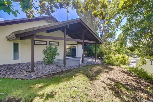 a view of a brick house with a small yard and wooden fence